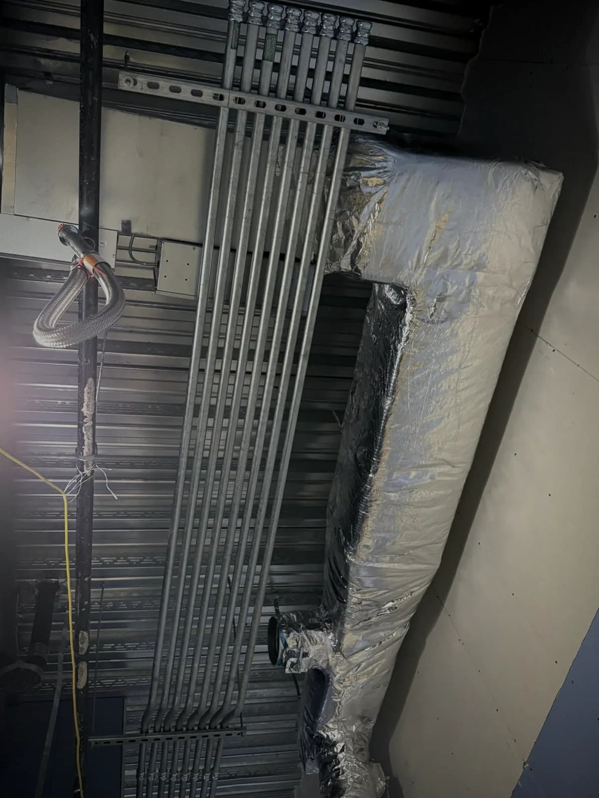 Conduit installation along an industrial ceiling