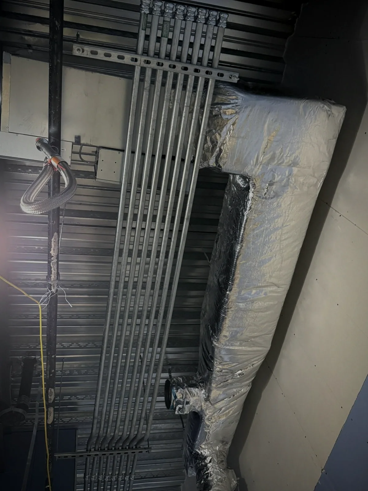Conduit installation along an industrial ceiling